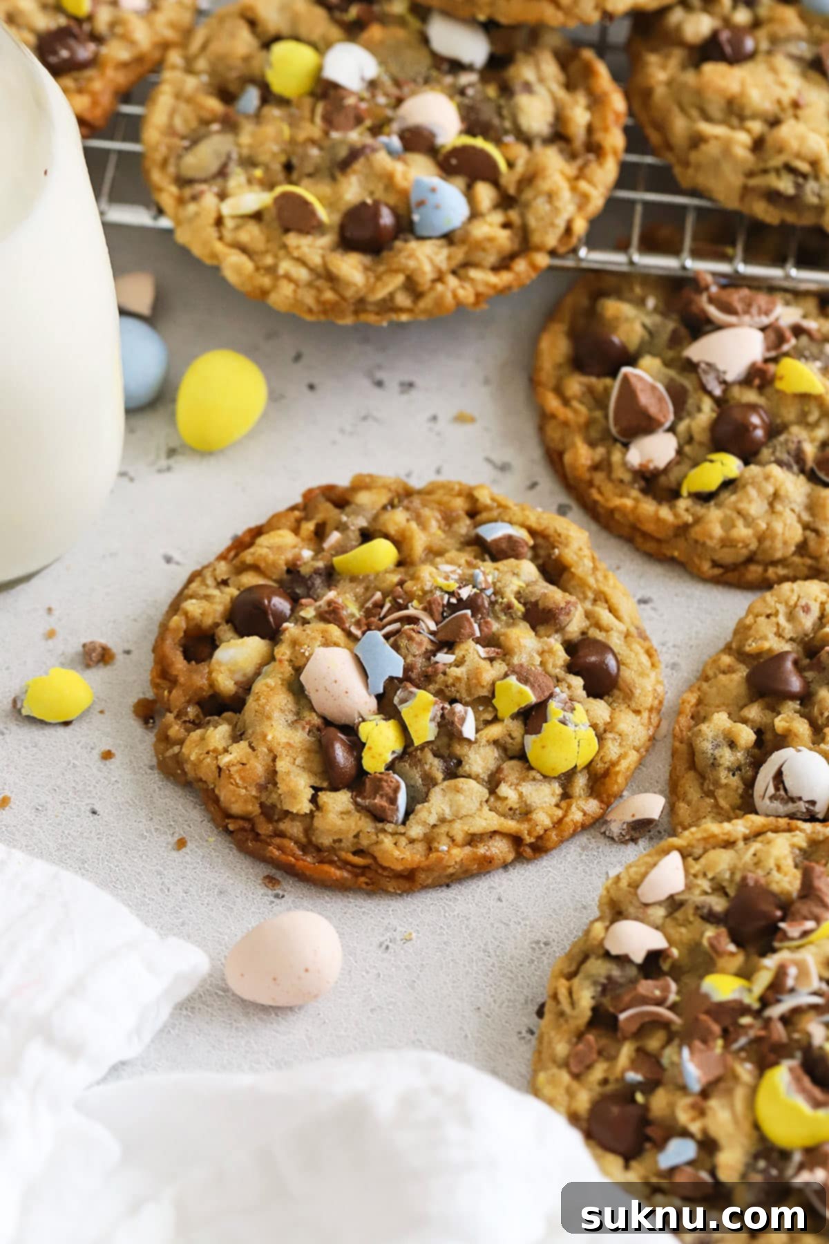 Irresistible Gluten-Free Cadbury Egg Cookies 2 gluten-free cadbury mini egg oatmeal cookies on a white background, perfect for an Easter celebration