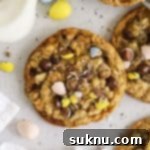 Irresistible Gluten-Free Cadbury Egg Cookies 12 gluten-free cadbury mini egg cookies on a white background with a bottle of milk and more cadbury egg candies scattered around