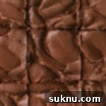 a pan of gluten-free brownies with chocolate frosting, cut into squares