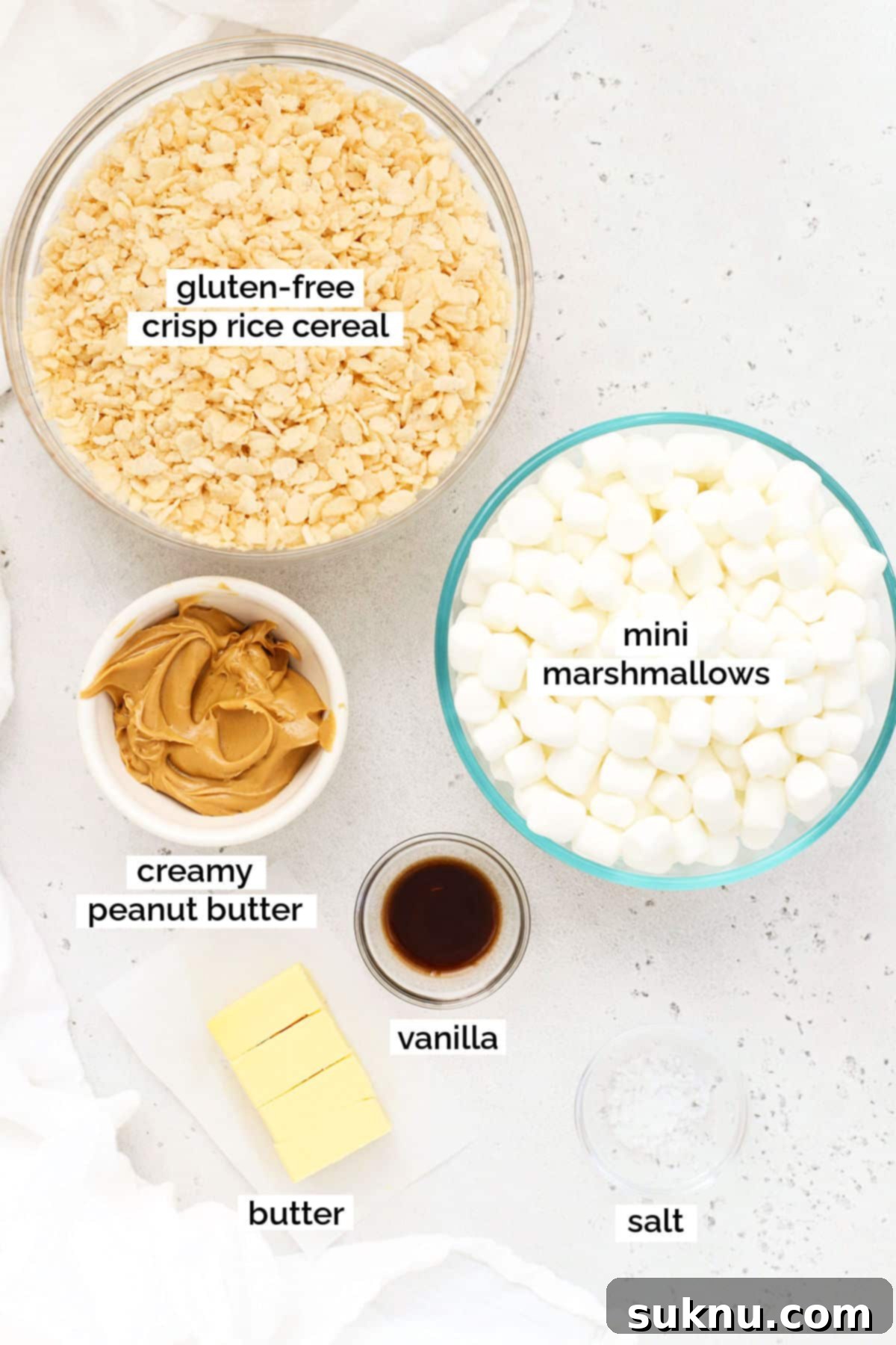 Ingredients for gluten-free peanut butter rice krispie treats laid out, including crisp rice cereal, marshmallows, peanut butter, vanilla, salt, and butter