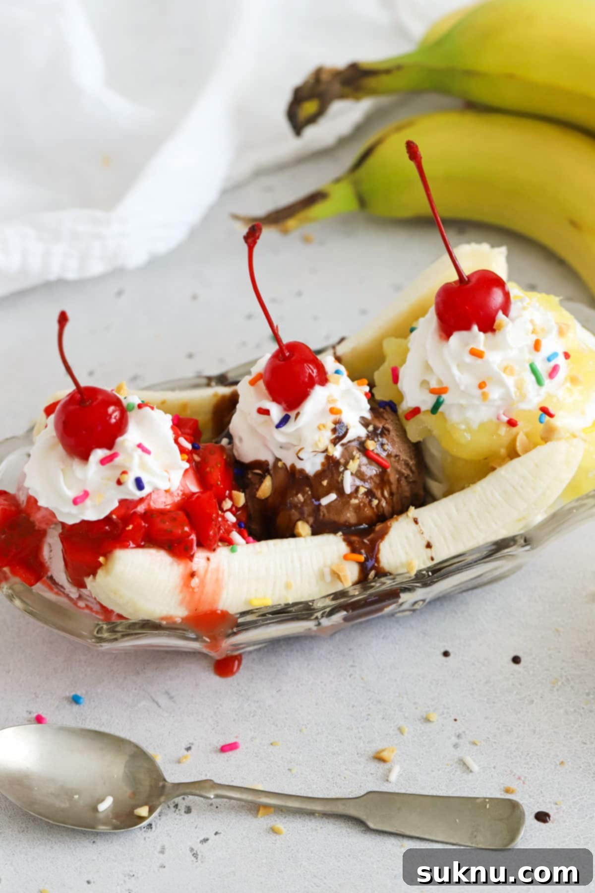 classic banana split with three ice cream flavors and three kinds of topping