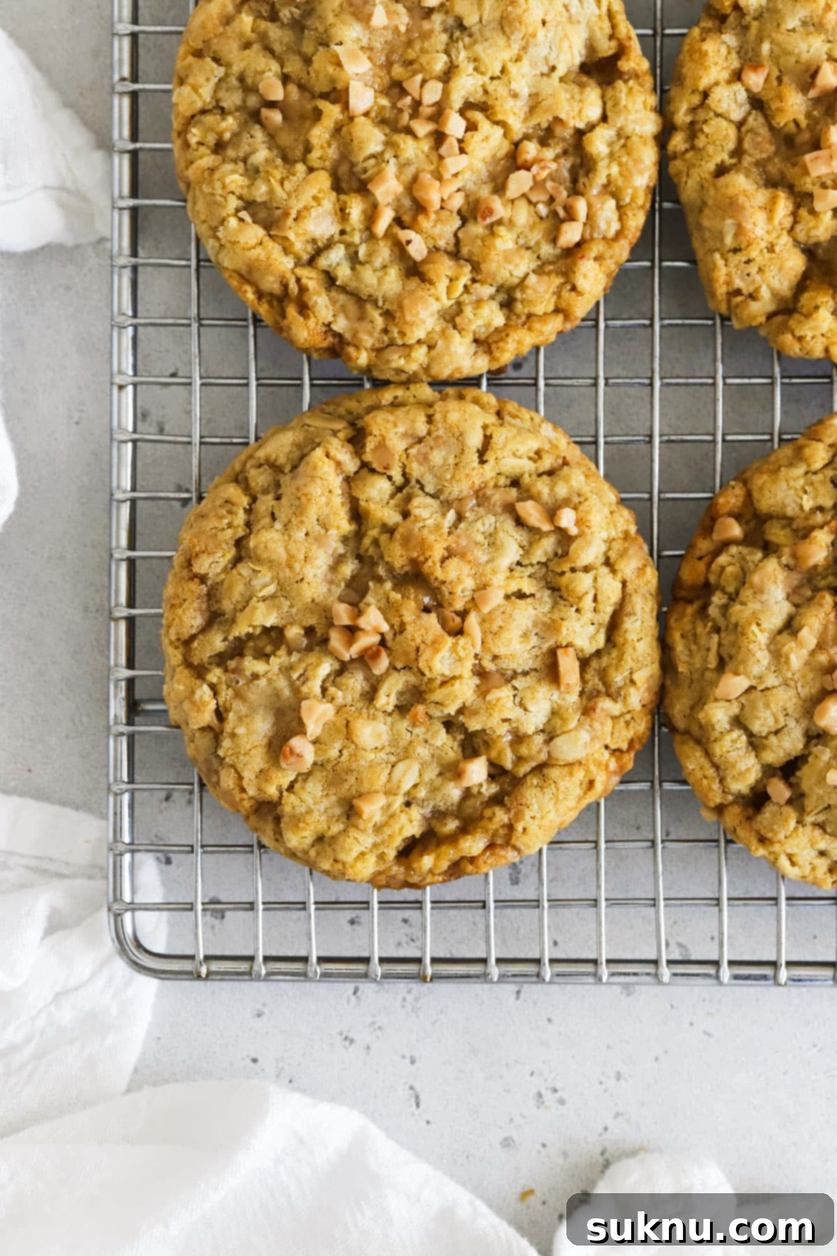 Chewy Gluten-Free Toffee Oatmeal Cookies 6 Golden-brown, perfectly baked gluten-free oatmeal toffee cookies cooling on a wire rack, ready to be enjoyed.