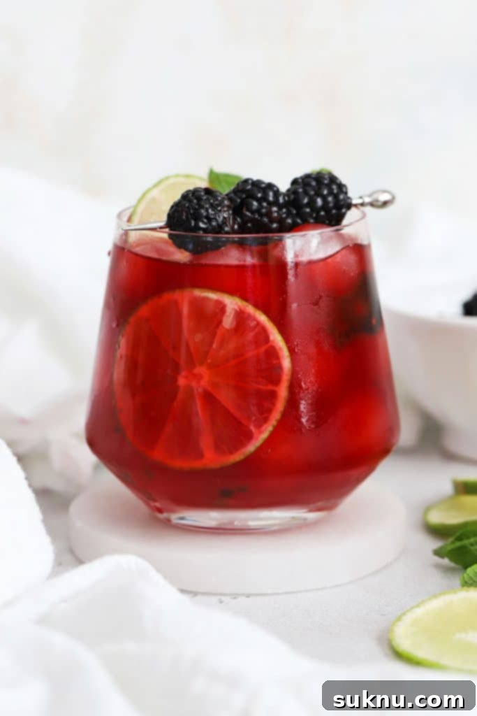 Refreshing Homemade Lemonade 7 A short glass of blackberry limeade garnished with fresh mint and blackberries, inviting for a summer sip.