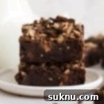 Decadent Gluten-Free Toffee Brownies 12 gluten-free toffee brownies stacked on a white dessert plate, tempting with their rich texture.