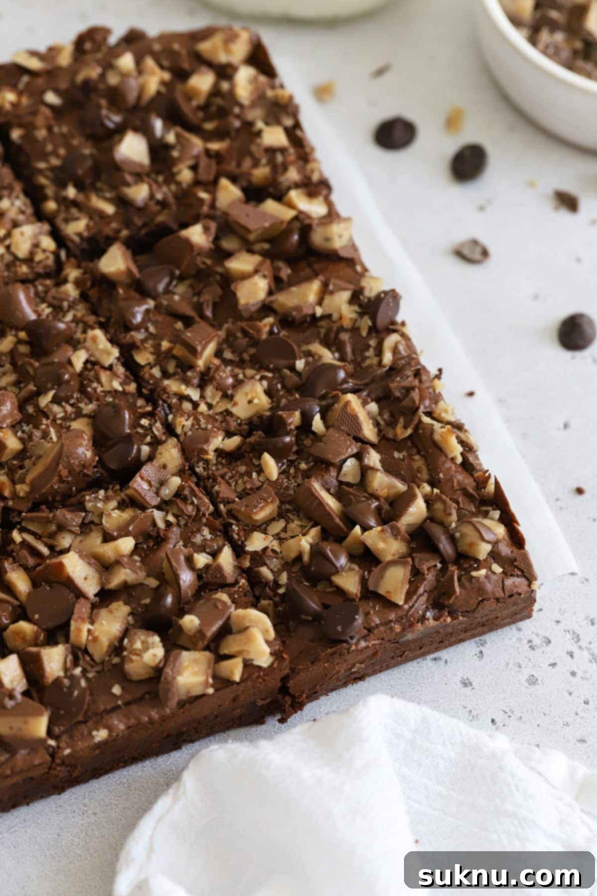 Decadent Gluten-Free Toffee Brownies 6 A close-up of a sharp knife expertly cutting through a batch of perfectly baked gluten-free toffee brownies into neat squares.