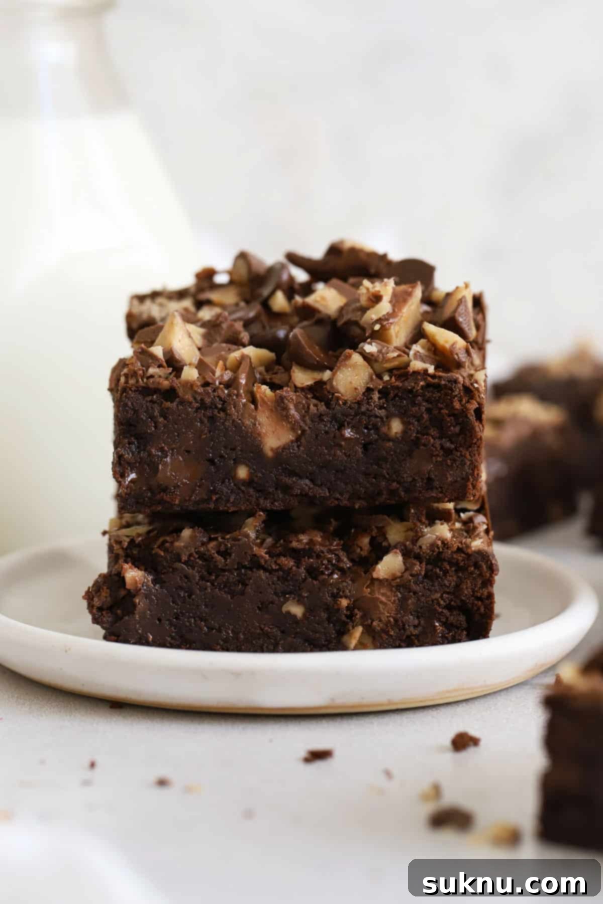 Decadent Gluten-Free Toffee Brownies 7 Perfectly stacked gluten-free toffee brownies on a white dessert plate, showcasing their fudgy texture and delicious toffee bits.