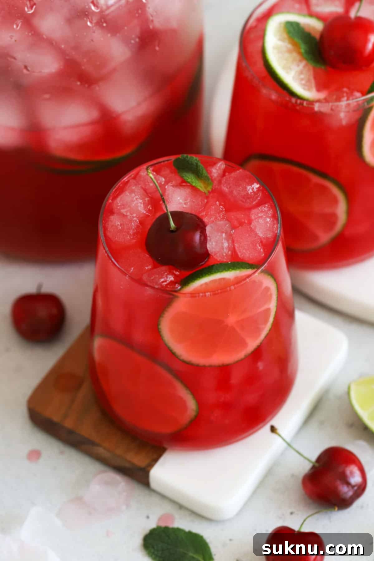 Glasses of sparkling homemade cherry limeade garnished with fresh cherries and lime slices