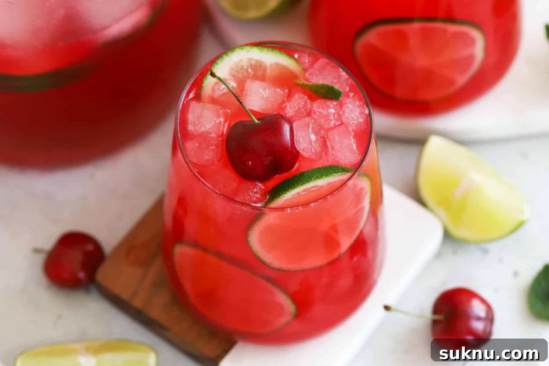 Cherry limeade topped with fresh cherries and lime slices in stylish glasses