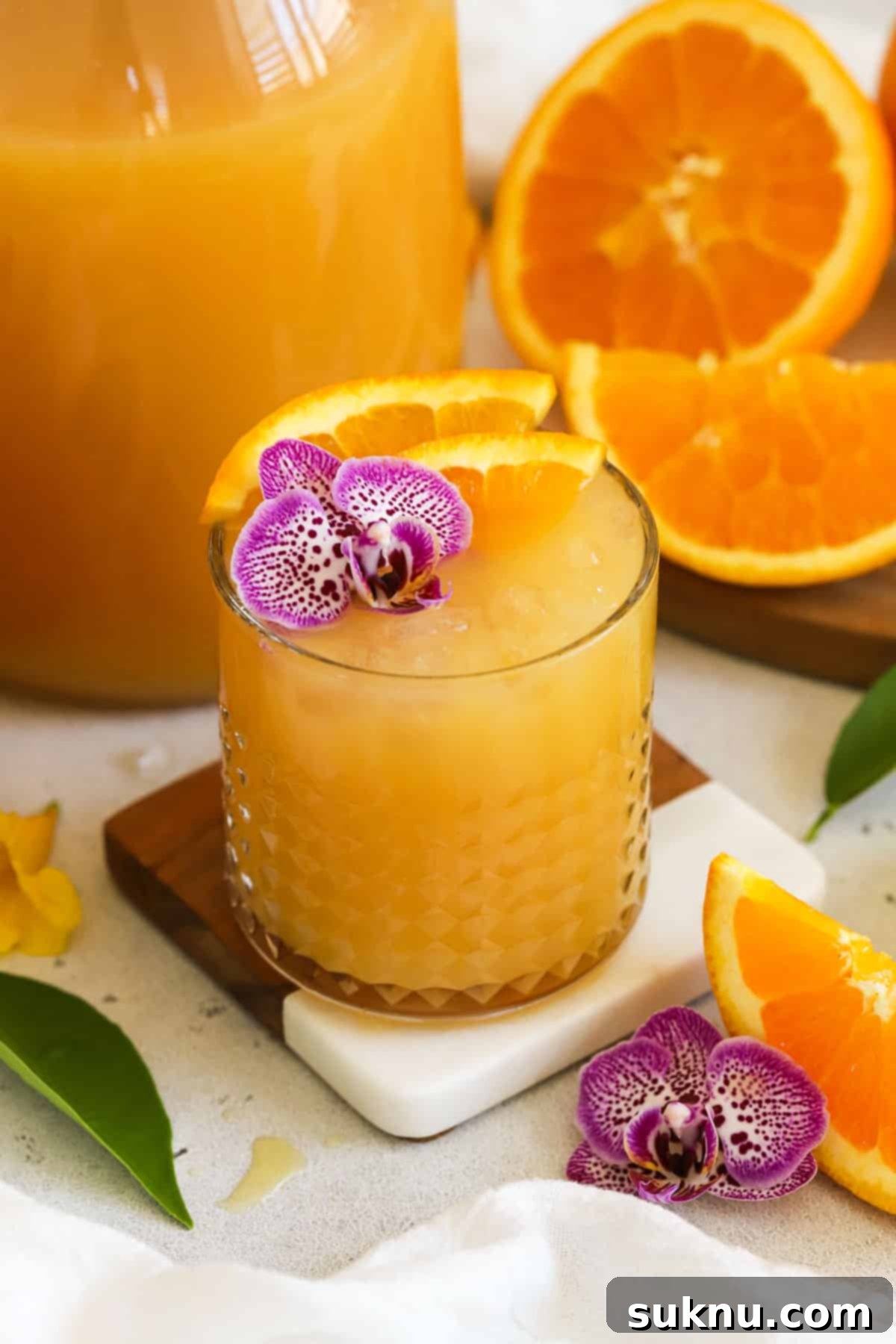 Homemade POG juice served in short glasses, garnished with citrus slices