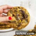 Pistachio Chocolate Chunk Gluten-Free Cookie Delights 10 hand holding a gluten-free brown butter chocolate chunk pistachio cookie