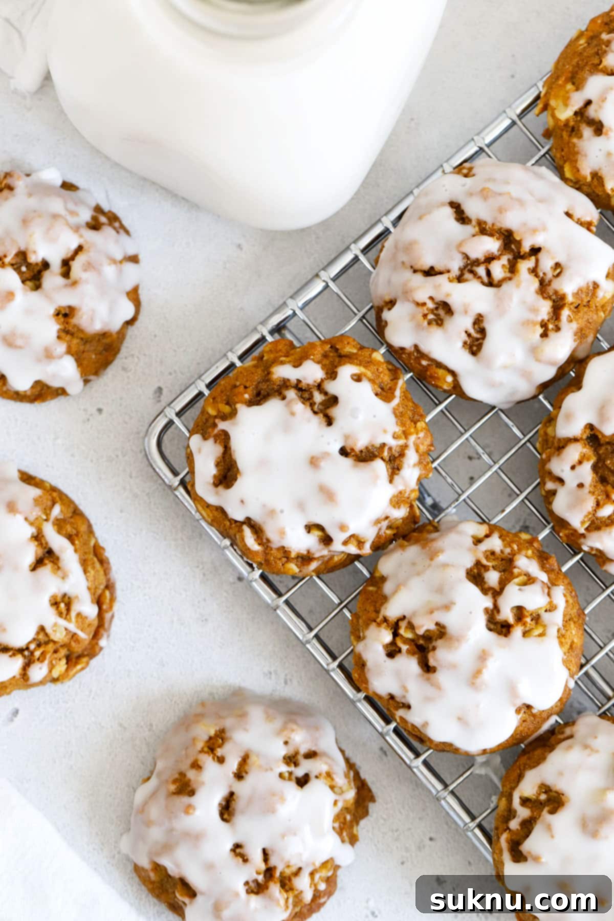 Autumn Spice Gluten-Free Pumpkin Oat Cookies 2 Vanilla glazed gluten-free pumpkin oatmeal cookies cooling on a wire rack, showcasing their soft, chewy texture and delicious fall flavors.