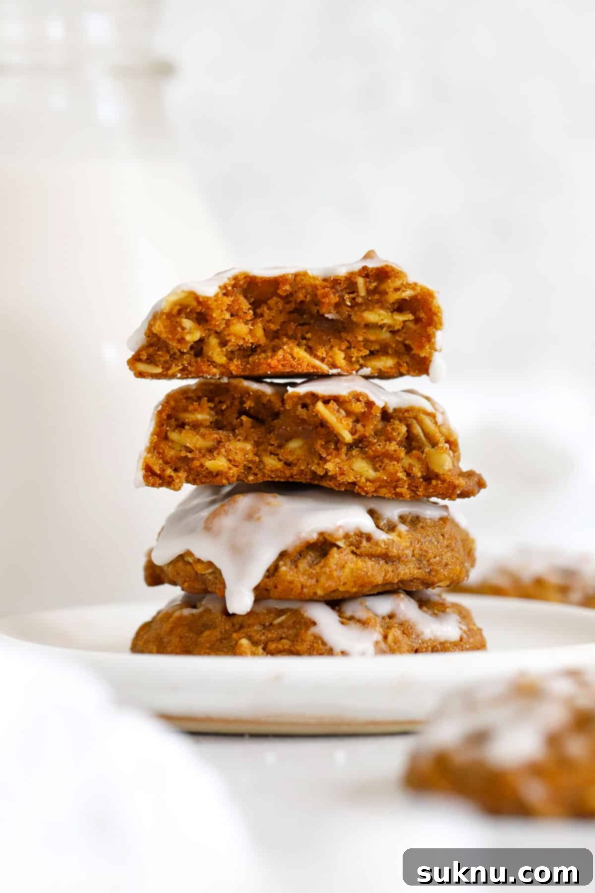 Autumn Spice Gluten-Free Pumpkin Oat Cookies 7 Stack of vanilla glazed gluten-free pumpkin oatmeal cookies on a white dessert plate, ready to be enjoyed.