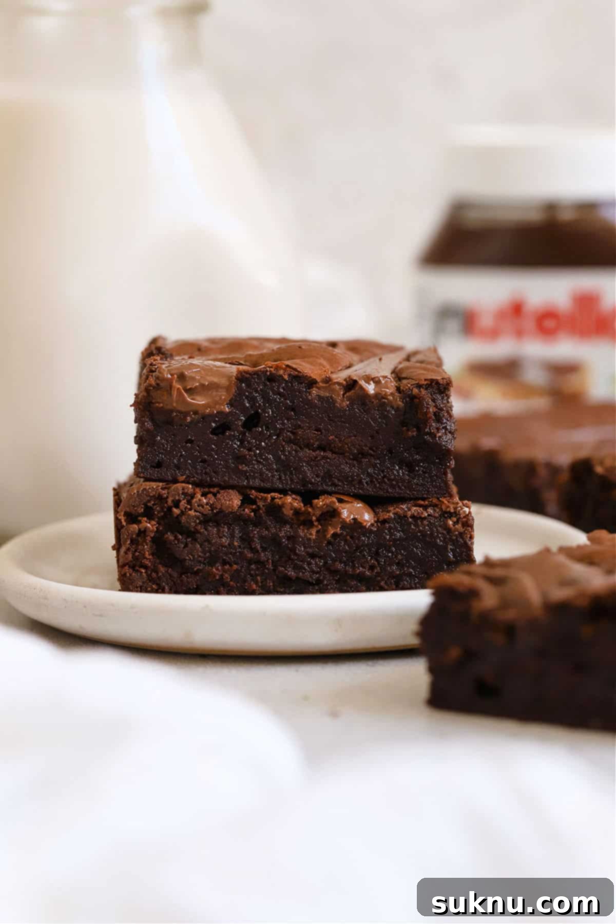 Stack of rich gluten-free Nutella brownies on a white plate