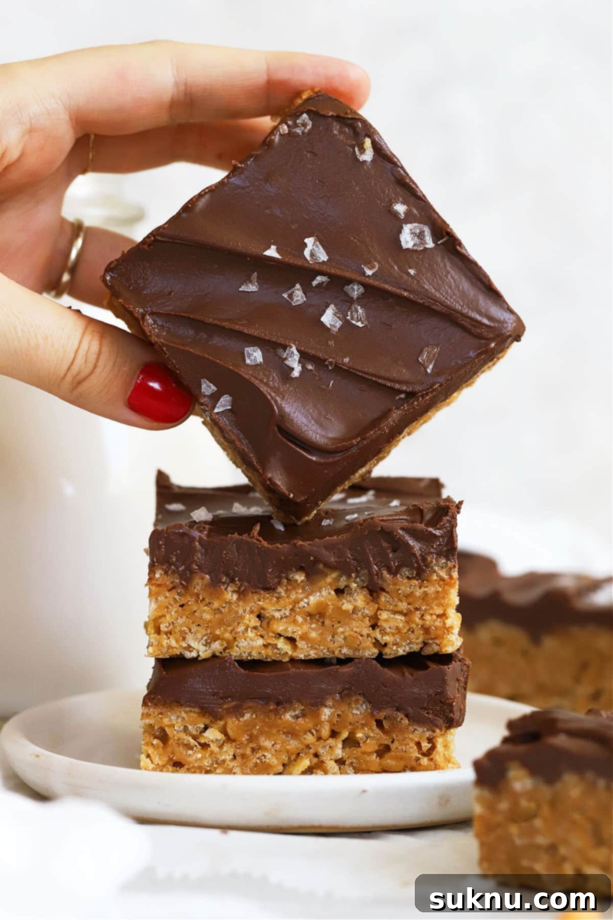 stacking gluten-free scotcheroos on a white dessert plate