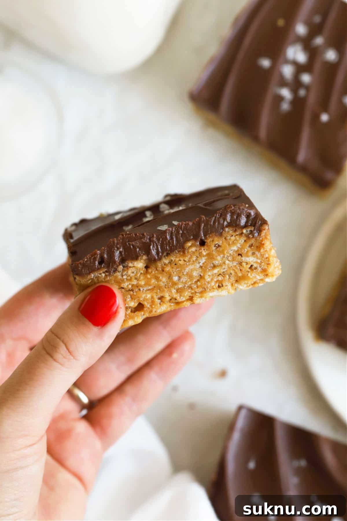 hand holding up a gluten-free scotcheroo to show the texture