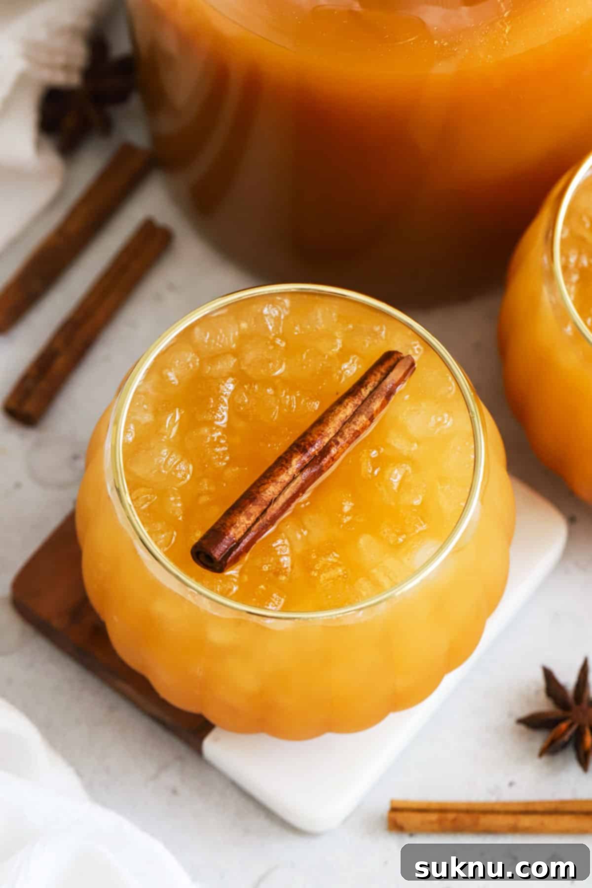 Enchanted Pumpkin Elixir 6 Two pumpkin-shaped cups filled with golden Harry Potter pumpkin juice, ready to be enjoyed.