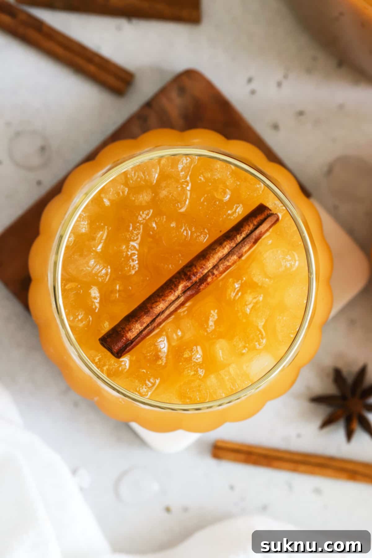 Enchanted Pumpkin Elixir 7 A vibrant pumpkin juice mocktail garnished elegantly with a cinnamon stick, capturing the essence of fall.