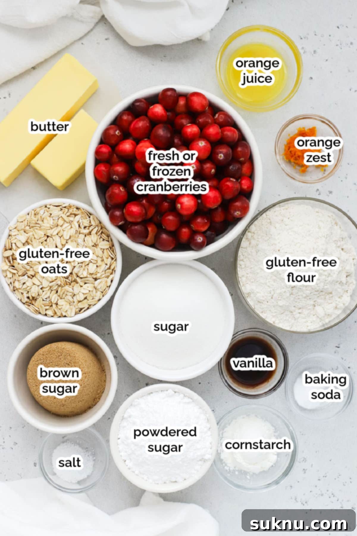 A close-up of fresh cranberries, butter, sugar, flour, and oats, highlighting the simple ingredients for gluten-free cranberry crumble bars.