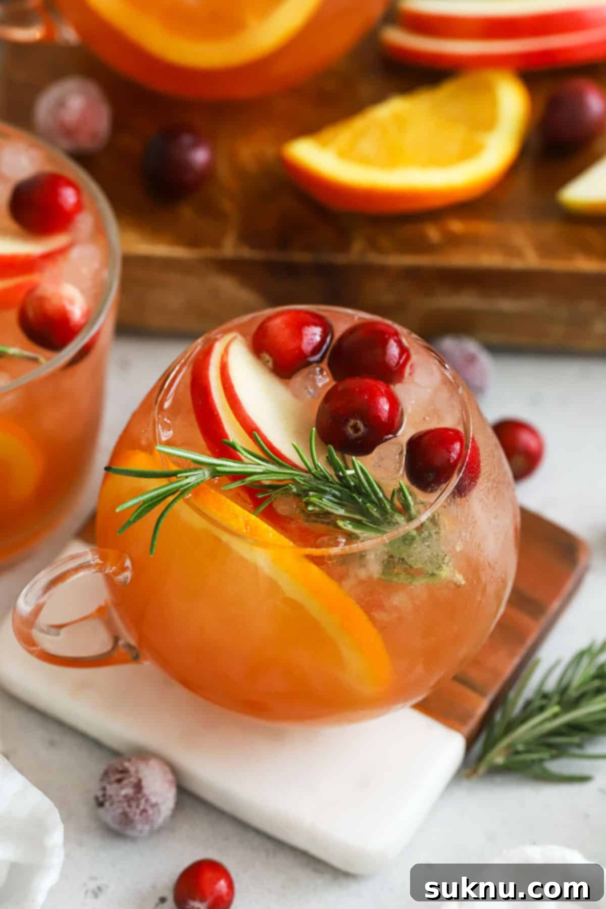 punch glasses of non-alcoholic holiday punch, garnished with orange slices and cranberries