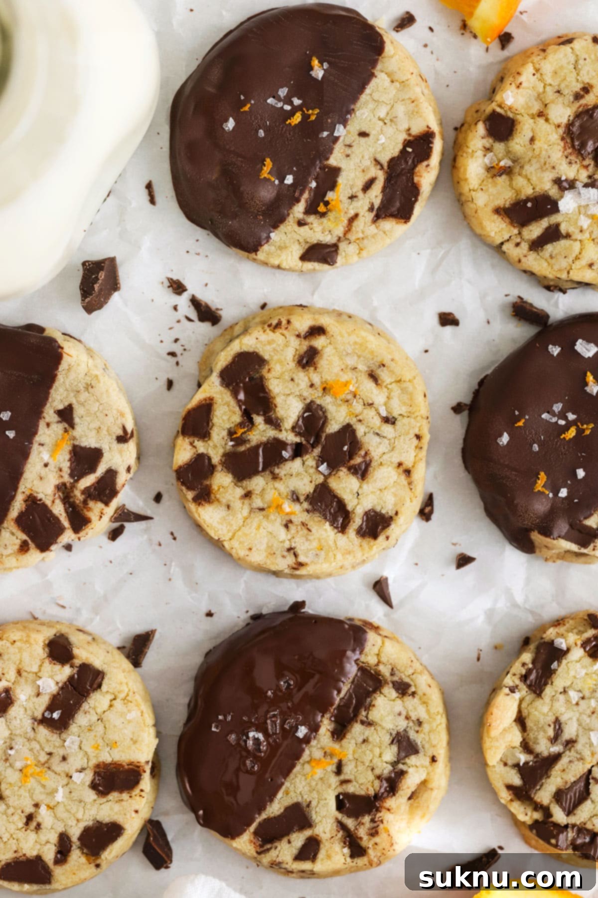 Wholesome Gluten-Free Orange Chocolate Buttery Bites 6 Chocolate-dipped Gluten-Free Orange Chocolate Chunk Shortbread cooling on parchment paper.