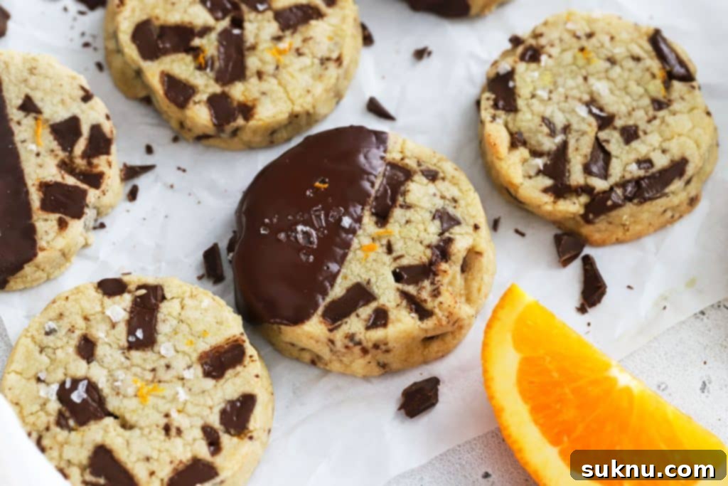 Gluten-free orange chocolate chunk shortbread cookies on parchment paper, rich and citrusy.
