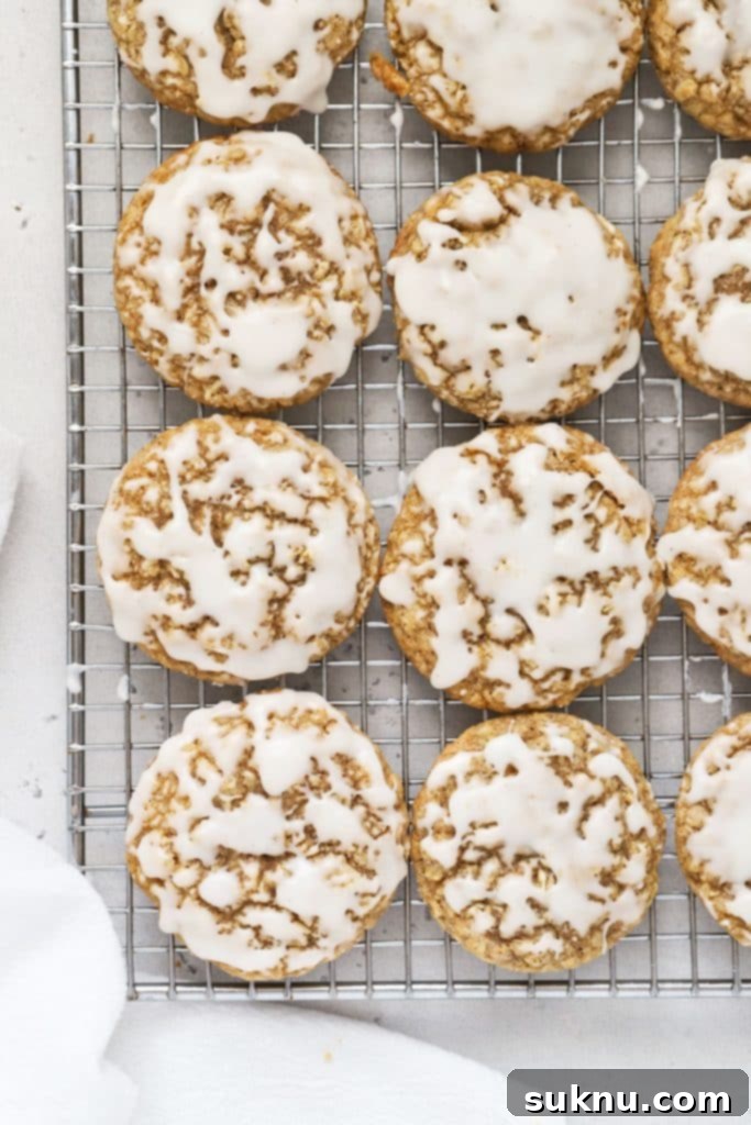 Gluten-free iced oatmeal cookies on a cooling rack, perfectly sweet and chewy.