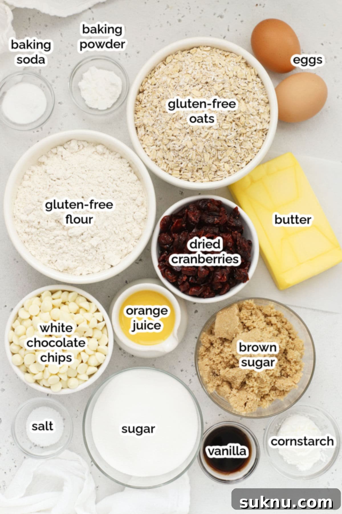 A flat lay photograph displaying all the fresh ingredients for gluten-free cranberry white chocolate chip oatmeal cookies.
