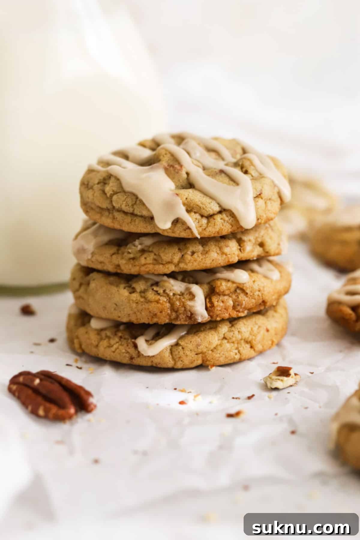 Gluten-free maple pecan cookies stacked next to a bottle of milk