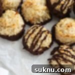 Chocolate dipped coconut macaroons on a sheet of parchment paper