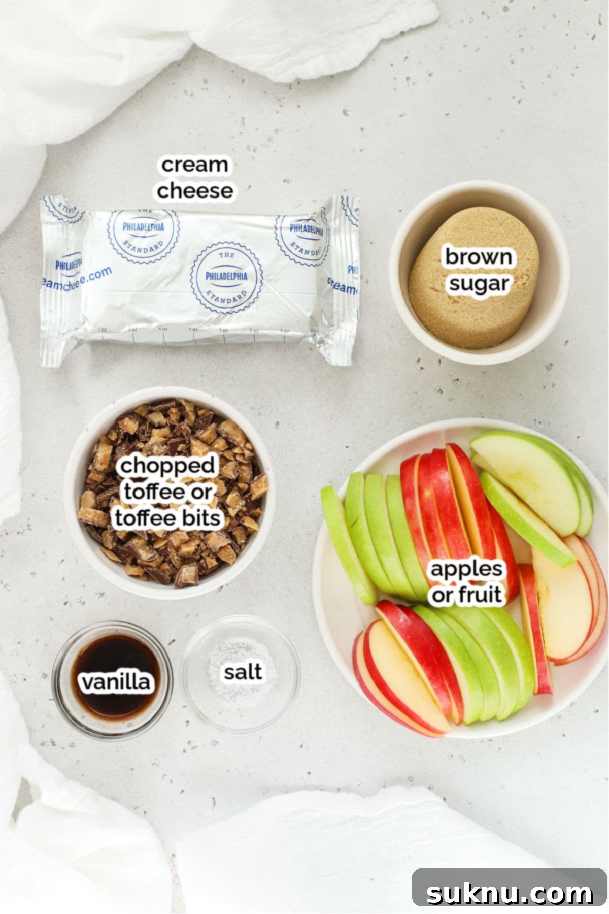 A selection of ingredients for cream cheese fruit dip with toffee bits, including cream cheese, brown sugar, vanilla, and toffee.