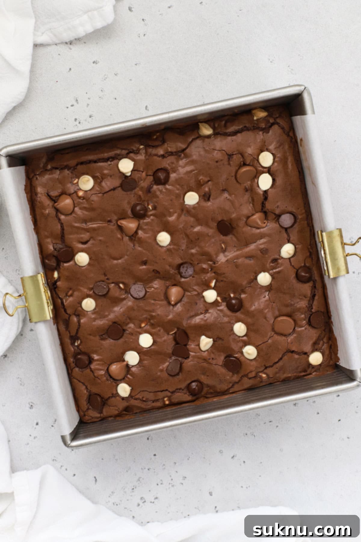 A freshly baked pan of gluten-free triple chocolate brownies, ready for slicing.