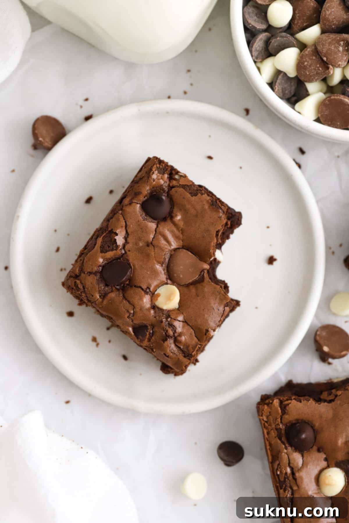 Close-up of a gluten-free brownie featuring distinct dark, milk, and white chocolate chips.