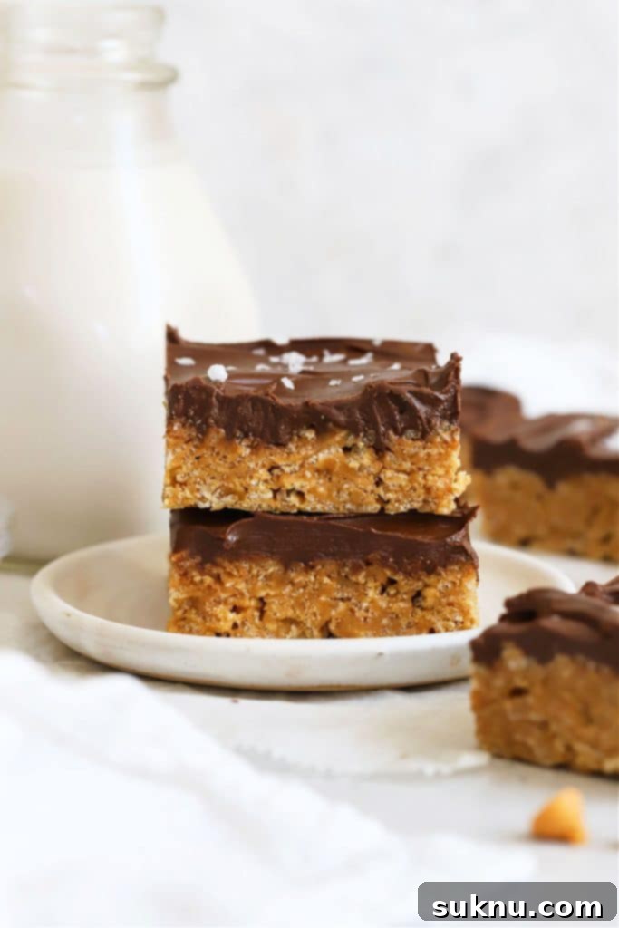 Gluten-Free M and M Rice Krispies Treats 8 Two perfectly stacked gluten-free Scotcheroos on a white dessert plate, showcasing their chocolate and butterscotch topping.