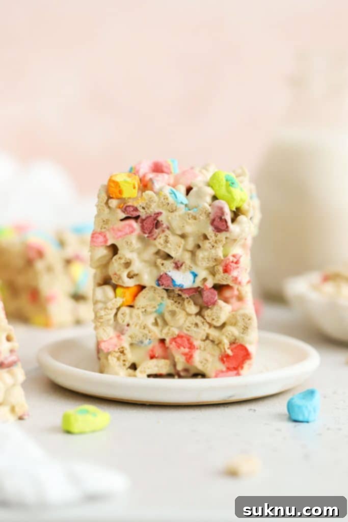 Gluten-Free M and M Rice Krispies Treats 9 Three gluten-free Lucky Charms treats stacked on a white plate, showing the colorful marshmallows.
