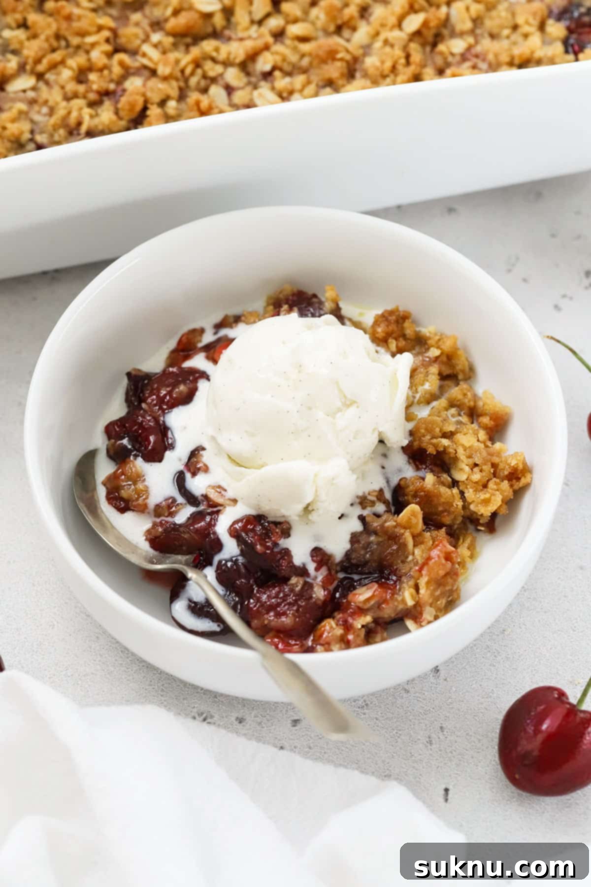 Luscious Gluten-Free Cherry Crisp 7 a bowl of gluten-free cherry crisp topped with vanilla ice cream