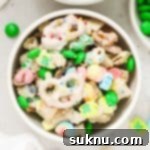 bowls of leprechaun bait snack mix next to a bowl of green m&ms