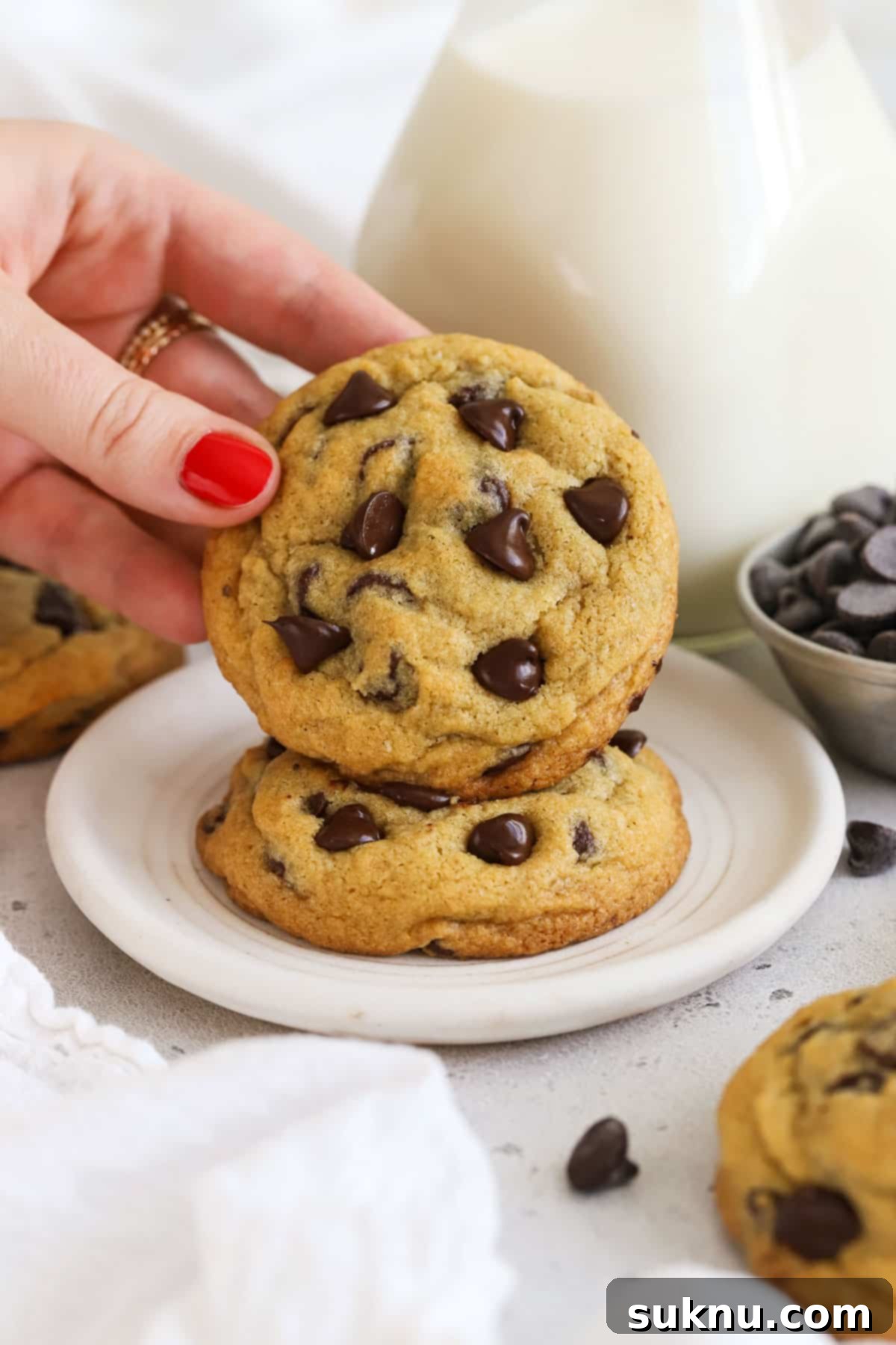 gluten-free pudding mix chocolate chip cookies stacked next to a bottle of milk