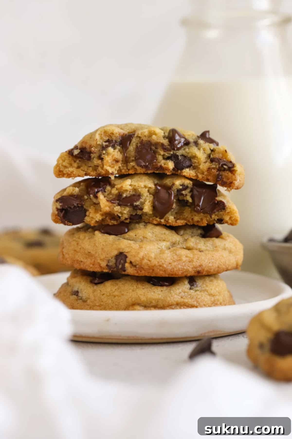 gluten-free pudding mix chocolate chip cookies stacked next to a bottle of milk