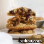 Gluten-Free Peanut Butter Oatmeal Chocolate Chip Delights 10 Gluten-free peanut butter oatmeal chocolate chip cookies stacked on a white dessert plate next to a bottle of milk, highlighting their soft, chewy texture.