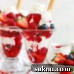 Homemade Knickerbocker Glory with raspberry sauce and fresh berries
