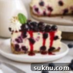 Luscious Gluten-Free Blueberry Cheesecake 12 A close-up of a slice of gluten-free blueberry cheesecake with cream and blueberries.