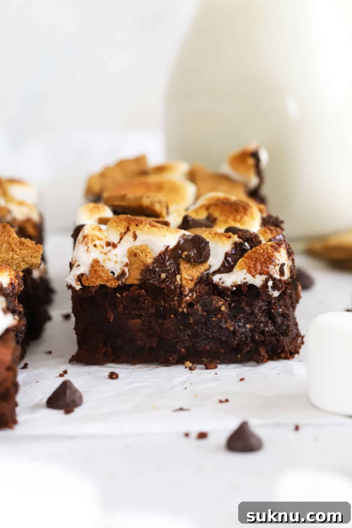 Decadent Gluten-Free S'mores Brownies 2 Irresistibly fudgy Gluten-Free S'mores Brownies, perfectly cut into squares, showcasing layers of graham cracker, chocolate, and toasted marshmallow.