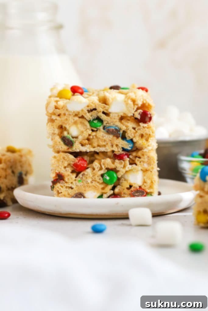 m&m rice krispie treats stacked on a white dessert plate