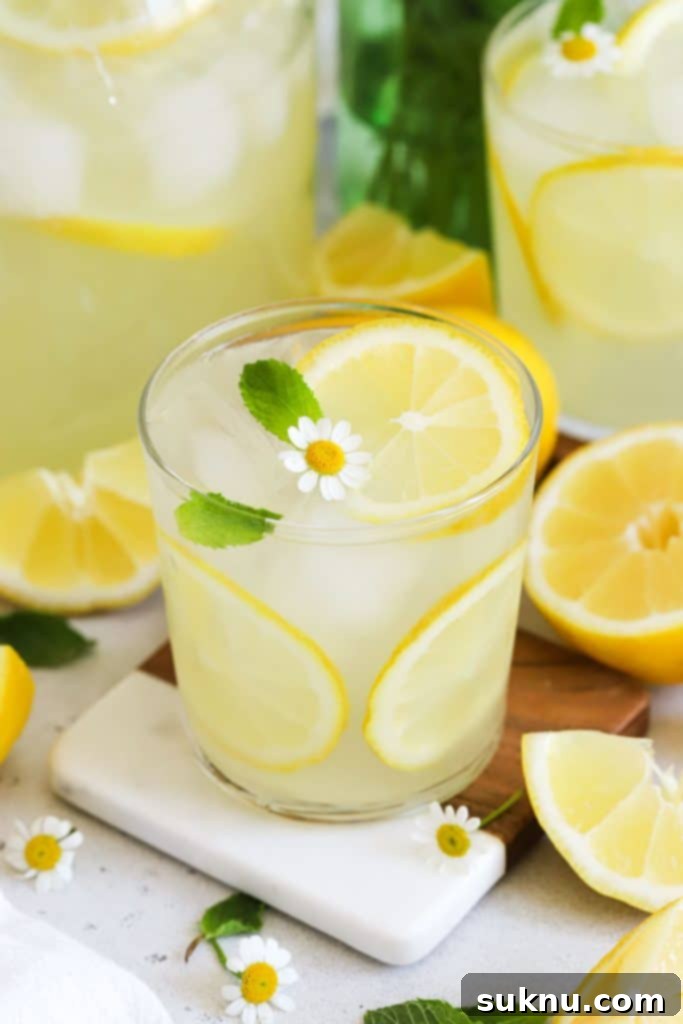 a glass of homemade lemonade garnished with fresh mint and lemon slices