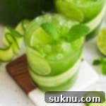 Crisp Cucumber Refreshment 10 Cucumber Mint Cooler garnished with a cucumber ribbon, fresh mint, and lime
