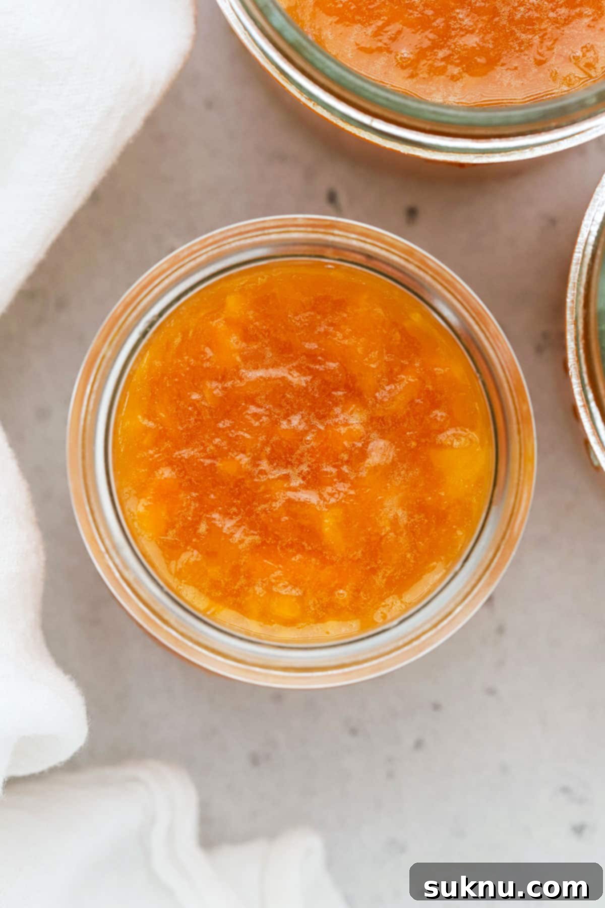 Effortless Low Sugar Peach Freezer Jam 6 Several jars of low sugar peach freezer jam neatly arranged, ready for storage.