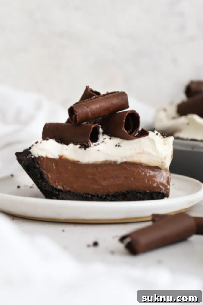 a slice of gluten-free chocolate cream pie topped with whipped cream and chocolate curls