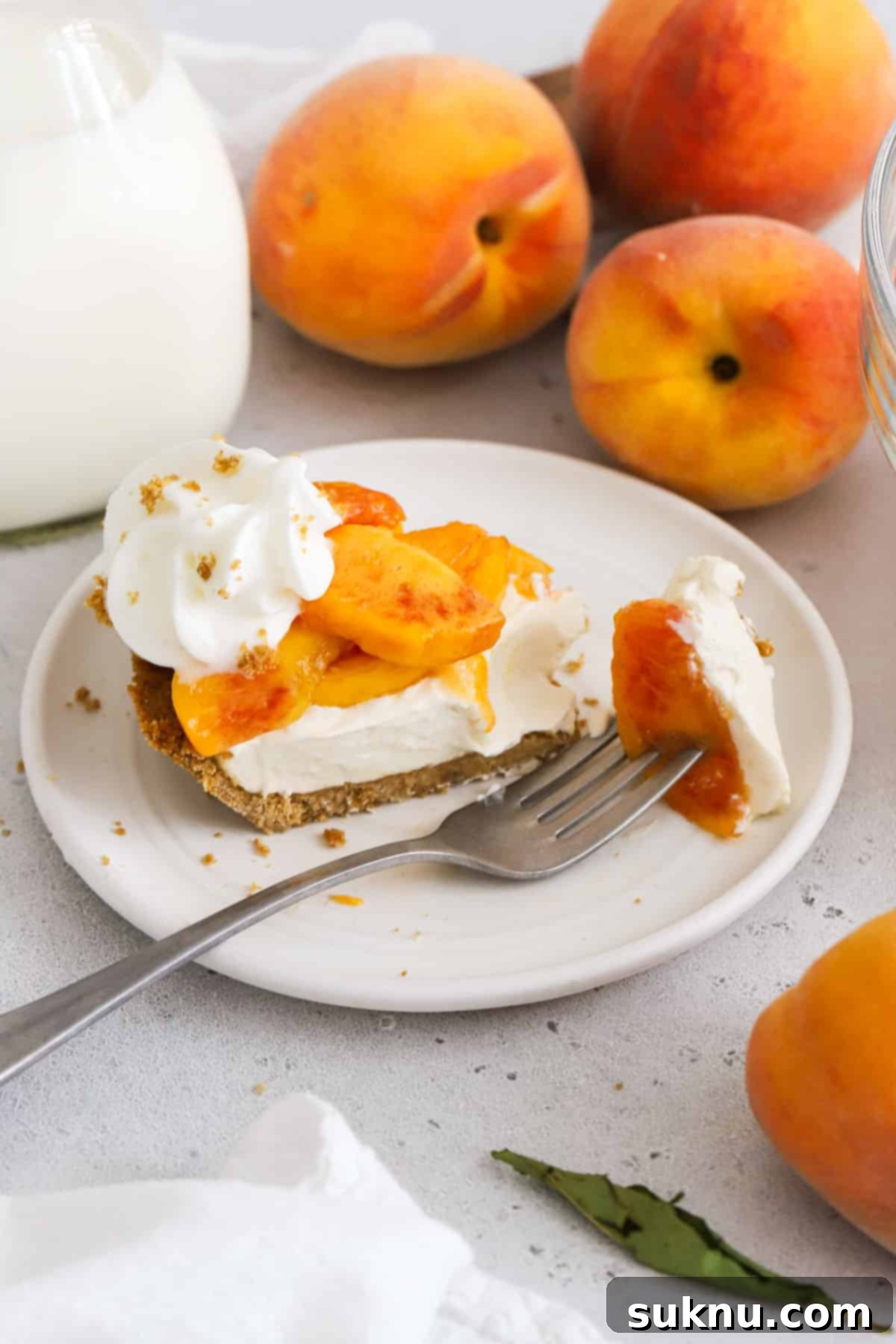 fork slicing a bite off a slice of gluten-free peaches and cream pie