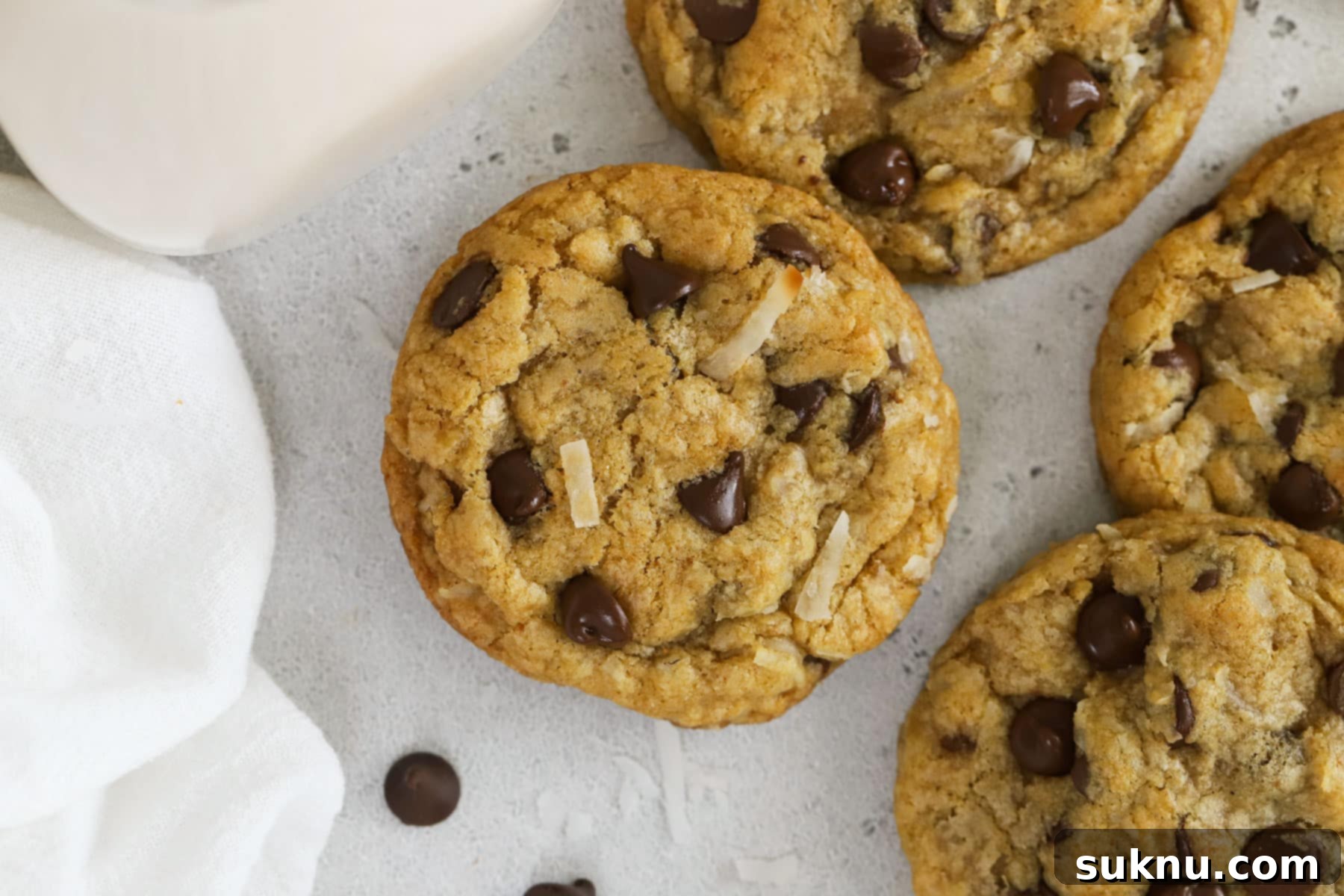 Gluten-free coconut chocolate chip cookies and a bottle of milk, beautifully presented.