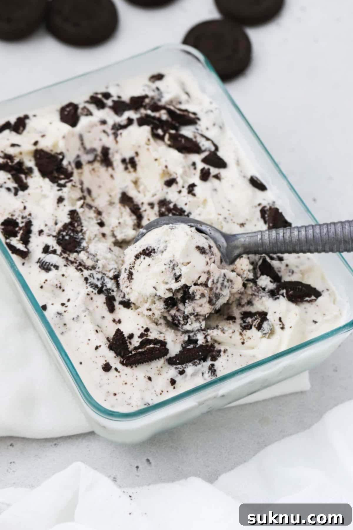 Scooping homemade gluten-free cookies and cream ice cream